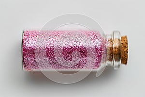 Pink glitters in bottle over white background