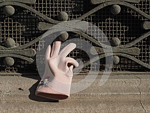 pink glove on window grate