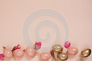 Pink and Gold Easter Eggs. Pastel Easter Concept with Eggs, Flowers and Feathers. Punchy Pastels. Copy Space. Eggs Frame