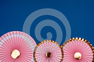 Pink and golden paper fans on classic blue drop