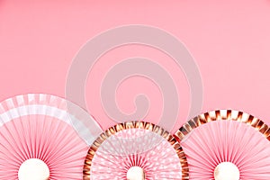 Pink and golden paper fans on pink drop