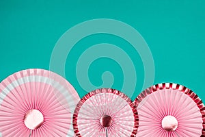 Pink and golden paper fans on turquoise drop
