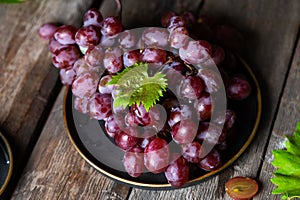 Pink grape on wooden table on wooden background. Vine grape. Still life of food.