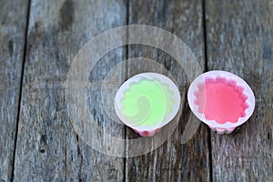 Pink and green jelly on wood background.
