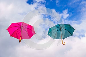 Pink and green umbrella or parasols floating suspended in the air