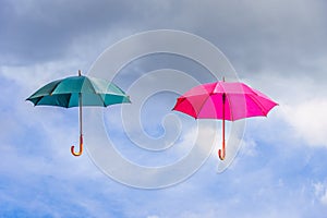 Pink and green umbrella or parasols floating suspended in the air