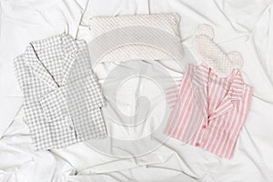 Pink and grey pajamas for men and women, and sleep mask for eye on white cotton bedsheet