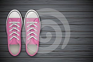Pink gumshoes Shoes on wooden background photo