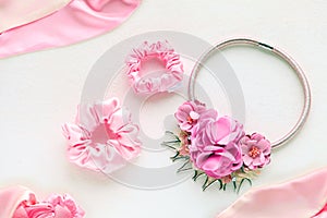 Pink hair accessories with roses. silk Scrunchy on white backdrop. Flat lay Hairdressing tools - violet textile Elastic