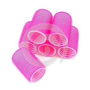 Pink hair curlers on white