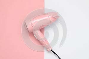 Pink hair dryer on pink and white background