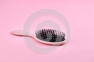 Pink hairbrush isolated on a pink coral background with space. beauty hair accessory for hairstyle