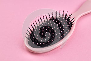 Pink hairbrush isolated on a pink coral background with space. beauty hair accessory for hairstyle