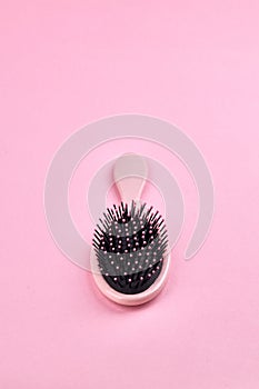 pink hairbrush isolated on a pink coral background with space. beauty hair accessory for hairstyle