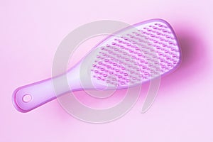 Pink hairbrush on pink background