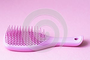 Pink hairbrush on pink background