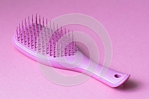 Pink hairbrush on pink background