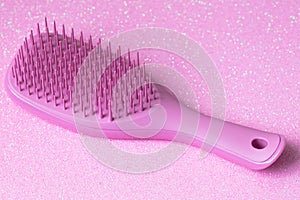 Pink hairbrush on pink background