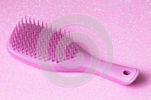 Pink hairbrush on pink background