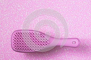 Pink hairbrush on pink background