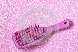 Pink hairbrush on pink background