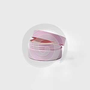 pink half-open jar of cream on a white background