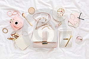 Pink handbag, camera, makeup brushes, cosmetics, sunglasses, accessories on white background. Flat composition. social