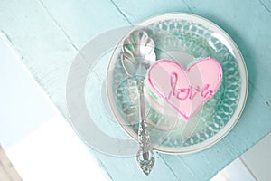 A pink heart cake with love message on the cake. Top view.