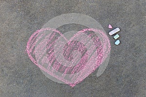 pink heart drawn with chalk on asphalt.