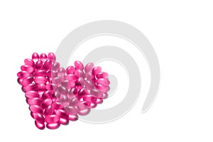 Pink heart made of vitamin on a white background.