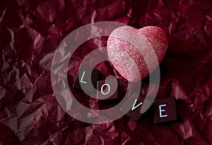 Pink heart on red background with love tiles