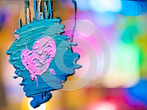 Pink heart shape on blue with colorful bokeh background