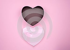 Pink heart-shaped gifts for Valentine`s Day open pink box, on a pink background