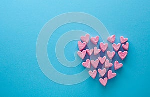 Pink heart-shaped marshmallows stacked on a blue background with space for copy. Marshmallow heart.Valentine`s day concept theme