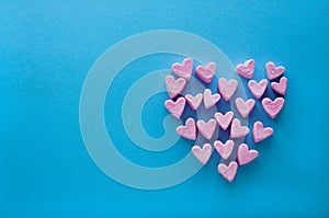 Pink heart-shaped marshmallows stacked on a blue background with space for copy. Marshmallow heart.Valentine`s day concept theme