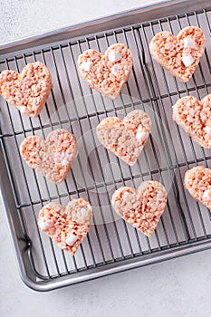 Pink heart shaped rice krispie treats on a cooling rack