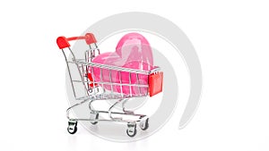 Pink heart in a shopping cart on a white background