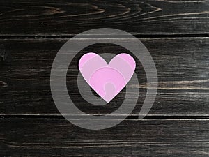 Pink heart on a wooden background.