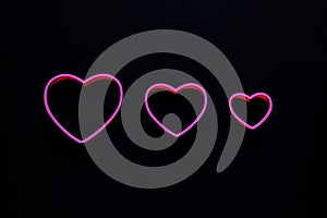 Pink hearts on black background for valentine`s day advertising baner