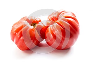 Pink heirloom tomato also called heritage tomato on white background. Natural, homegrown, imperfect tomatoes.