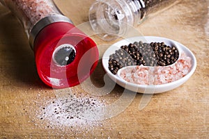 Pink Himalayan Salt and Black peppercorns in ying yang dish and grinders