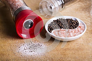 Pink Himalayan Salt and Black peppercorns in ying yang dish and grinders photo