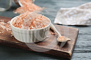 Pink himalayan salt in bowl and spoon on wooden board