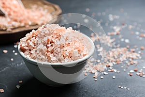 Pink himalayan salt in ceramic bowl on black table