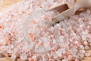 Pink himalayan salt. Close-up Himalayan Pink Rock Salt In wooden Spoon on black background. Fine grains of Pink Himalayan salt