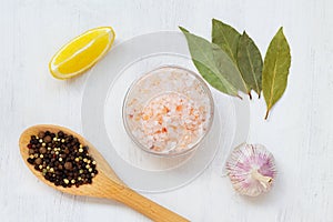 Pink Himalayan salt on the glass bowl, Bay leaf, piece of lemon, fresh garlic and mix of peppers