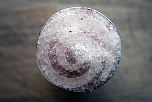 Pink Himalayan salt in a metal container on a wooden board