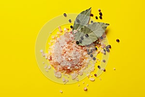 Pink himalayan salt and spices on yellow background