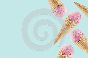 Pink ice cream in crisp waffle cones as decorative border on pastel green background, mock up, copy space.