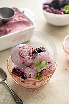 Pink ice cream scoops in glass bowl, close up. Homemade healthy sorbet with banana and berry, icecream refresing treat photo